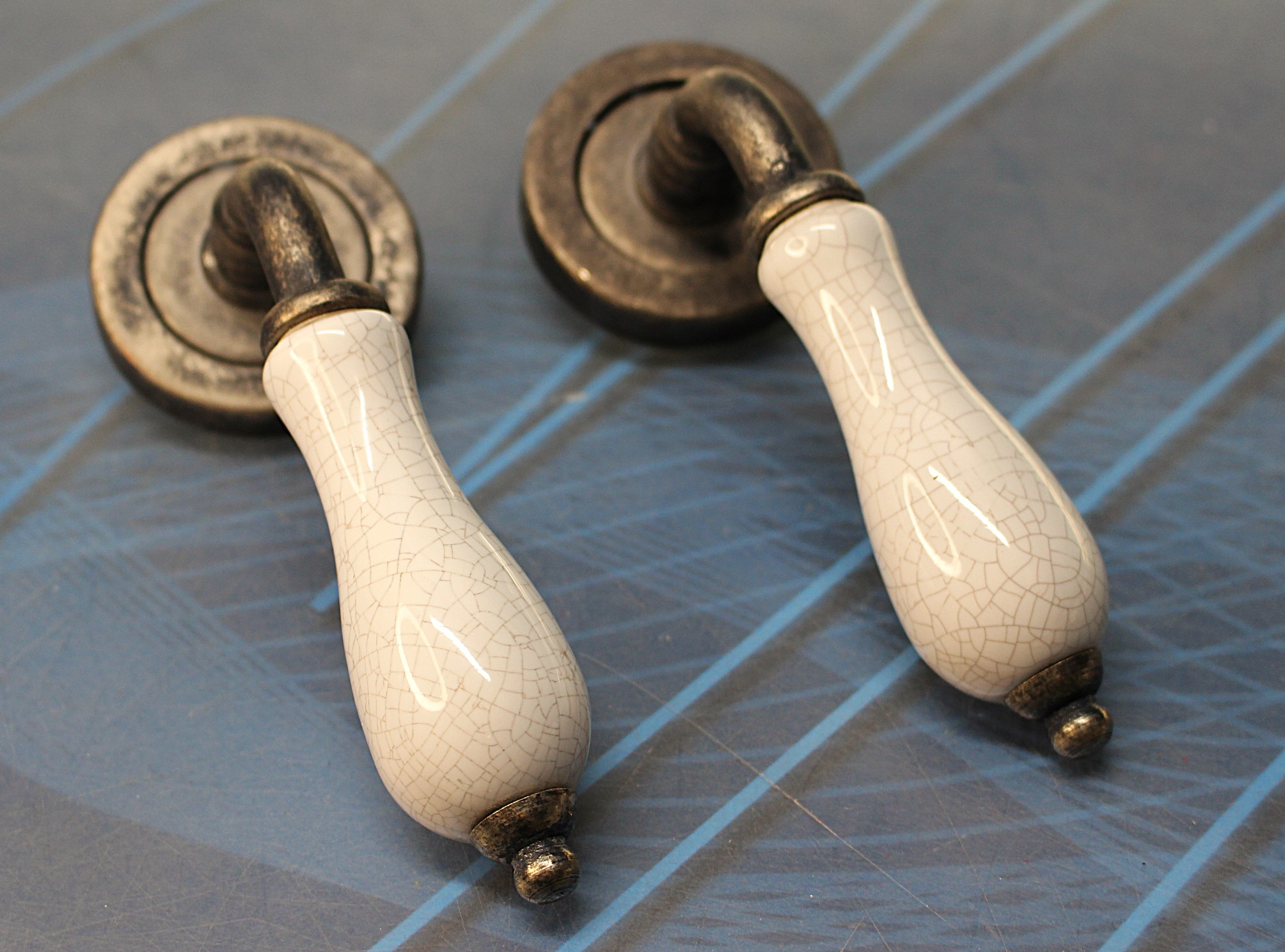 Manillas aluminio y porcelana craquelada.