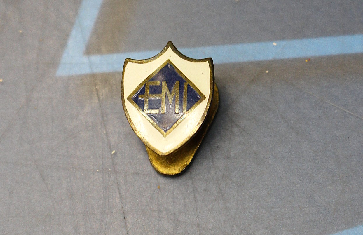 Pin, insignia EMI, Escuela Mandos Intermedios o una marca de electrodomésticos.
